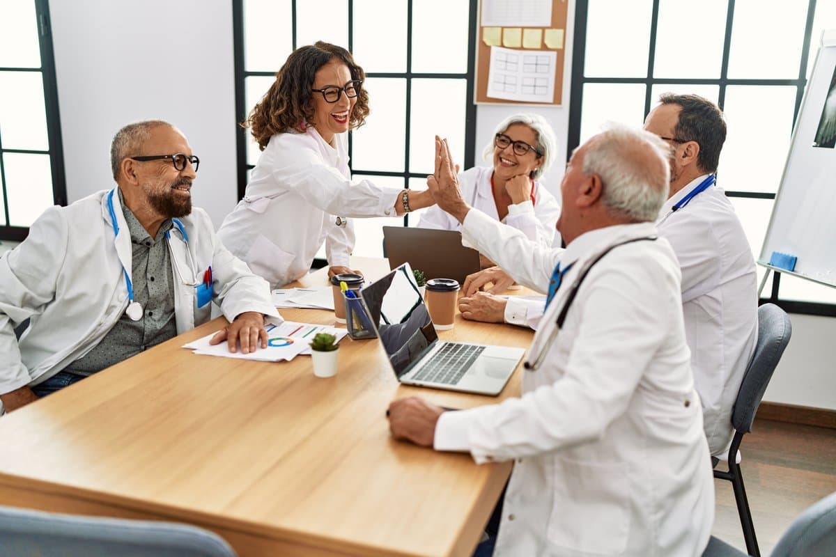 Satisfied healthcare professionals collaborating after implementing fair transparent scheduling