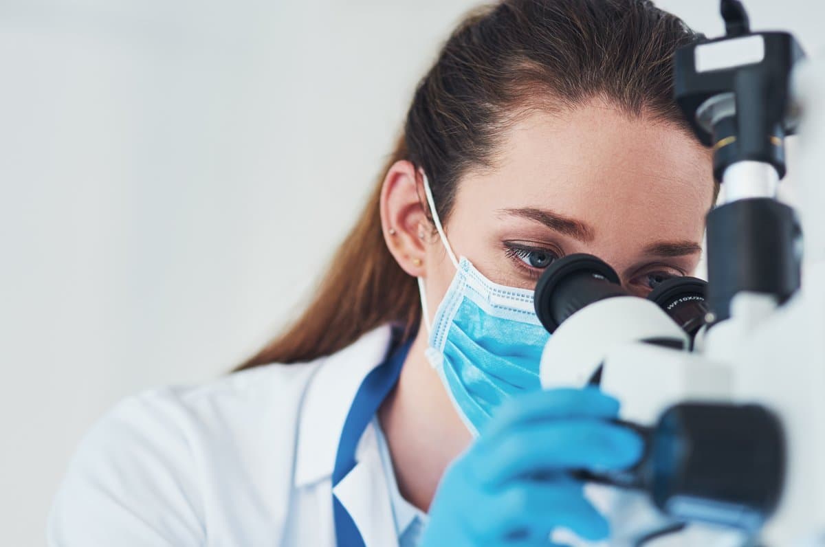 Pathologist working at microscope in a modern diagnostic laboratory
