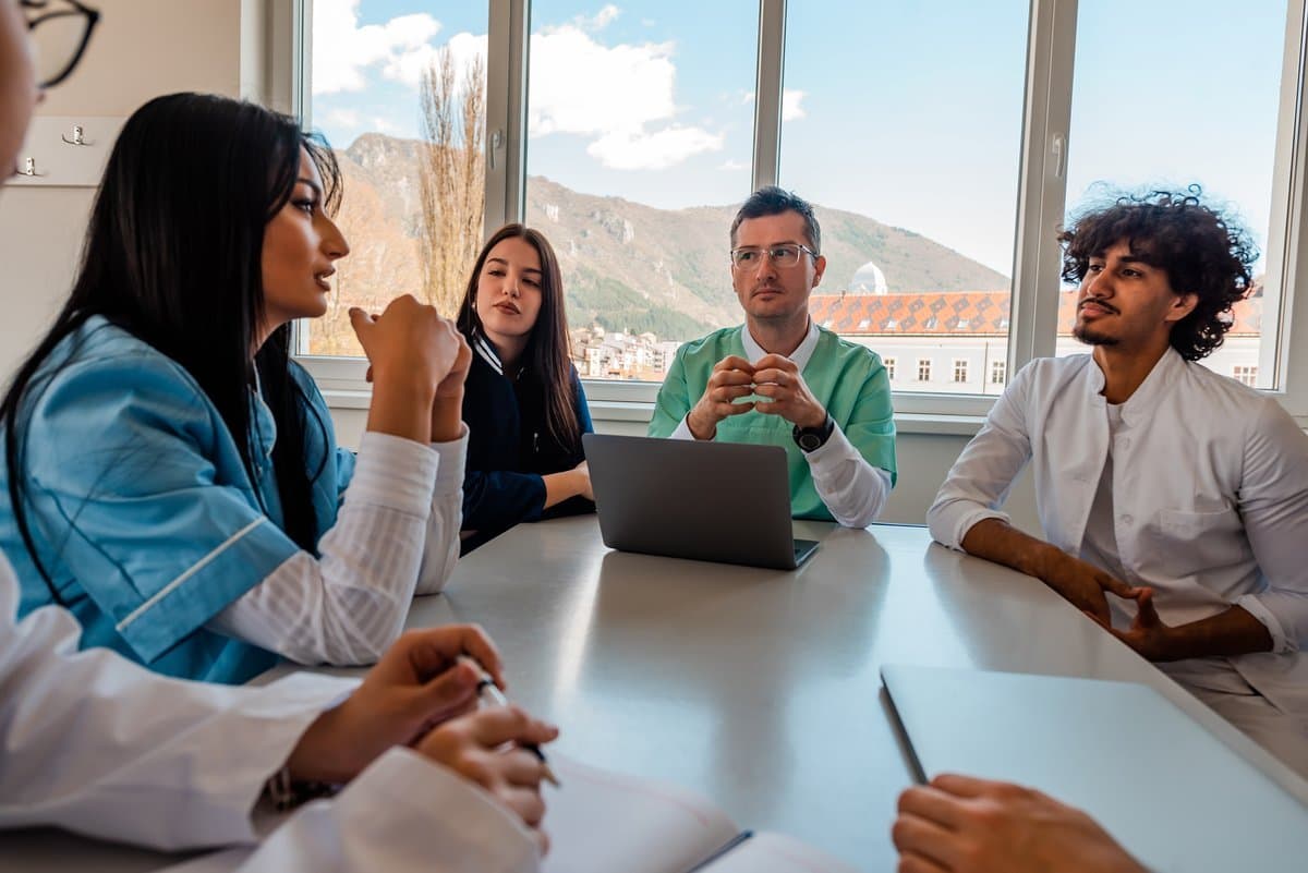 Small medical practice team collaborating on staff scheduling and roster planning