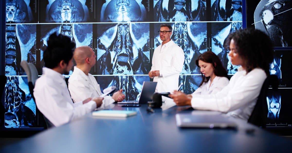 Medical imaging specialists reviewing and discussing cases together in a collaborative setting