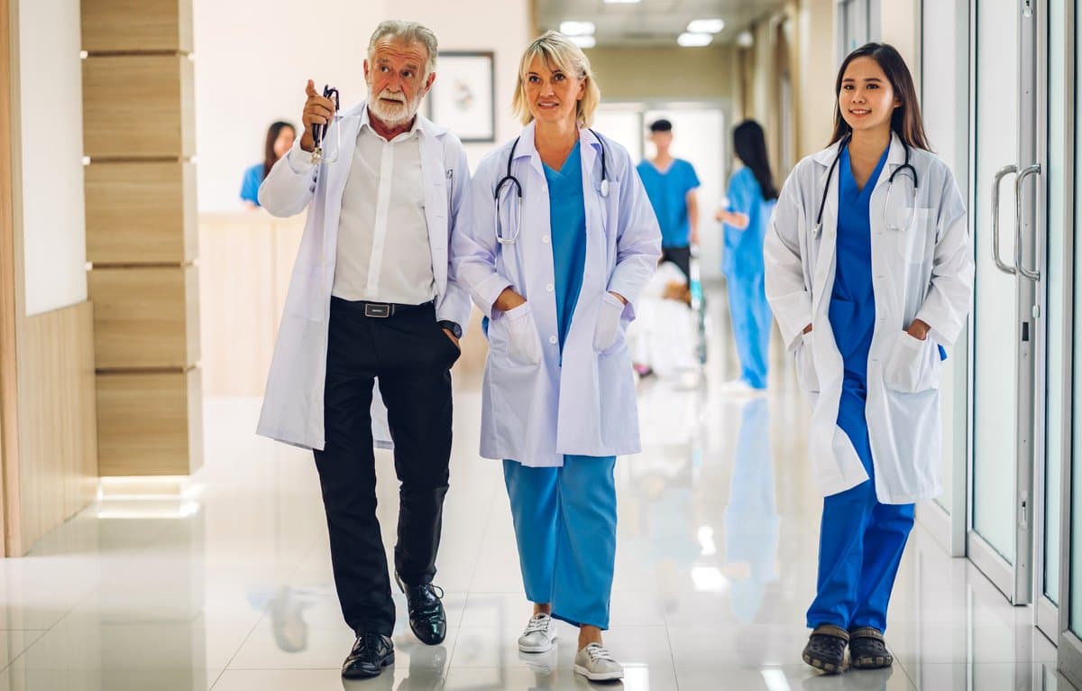 Specialist doctors walking together through a hospital corridor in a relaxed confident moment